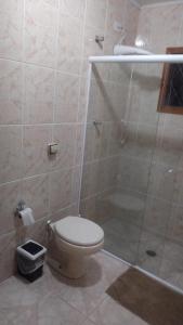 ein Bad mit einem WC und einer Glasdusche in der Unterkunft Cantinho aconchegante in Campos do Jordão