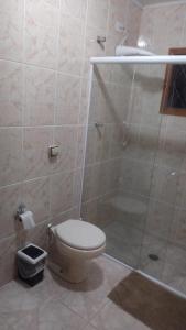 a bathroom with a toilet and a glass shower at Cantinho aconchegante in Campos do Jordão +15 photos