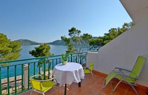 a balcony with a table and chairs and a view of the water at Apartments Luka in Ubli