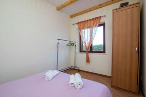 a bedroom with a purple bed and a window at Apartments Luka in Ubli +25 photos