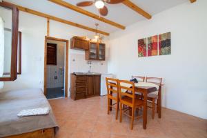 a kitchen and dining room with a table and chairs at Apartments Luka in Ubli