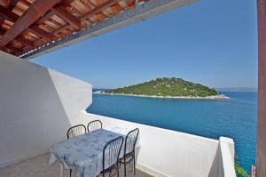 a table and chairs on a balcony overlooking the ocean at Apartments and Rooms Barbara in Lastovo