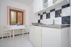 a kitchen with a sink and a table and a window at Apartments and Rooms Barbara in Lastovo