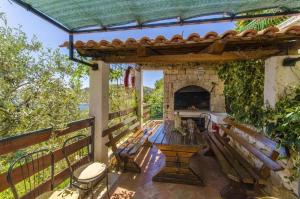 eine Außenterrasse mit Bänken und einem Kamin in der Unterkunft Apartments Otjana in Sevid