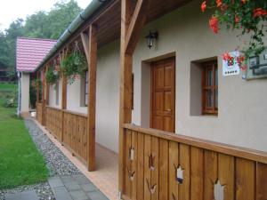 a house with a fence and a wooden door at Kőhíd Vendégház in Abaújvár