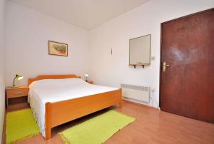 a bedroom with a bed and a door with a mirror at Apartments Slavica in Ubli