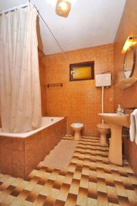 a bathroom with a tub and a toilet and a sink at Apartments Slavica in Ubli