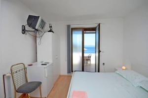 a bedroom with a bed and a tv and a chair at Apartments and Rooms Barbara in Lastovo