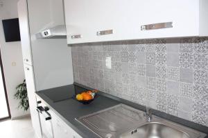 a kitchen with a sink and a bowl of fruit at Apartments and Rooms Barbara in Lastovo