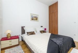 sypialnia z białym łóżkiem i czerwoną szafką nocną w obiekcie Apartment Zvonimir w mieście Sumpetar
