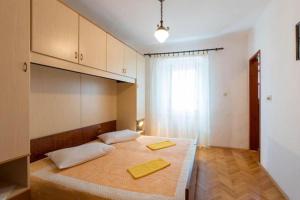 a bedroom with a large bed with two yellow towels on it at Apartments Ivan in Mali Lošinj
