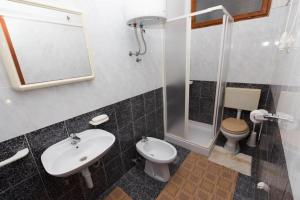 a bathroom with a sink and a toilet and a shower at Apartments Ivan in Mali Lošinj