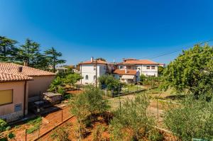 a group of houses in a yard with trees at Apartments Marija in Umag