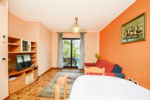 una camera da letto con pareti arancioni, un letto e una TV di Apartments Marija a Umag (Umago)