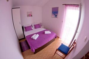 a bedroom with a purple bed and a blue chair at Apartment Marija in Donje Selo na Šolti