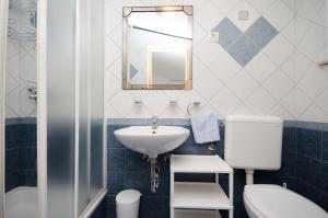 a bathroom with a sink and a toilet and a mirror at Apartments Jasminka in Selce