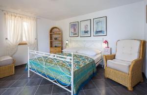 a bedroom with a bed and two chairs at House Vesna Kupinova in Milna +60 photos