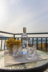 butelka i dwie szklanki siedzące na stole w obiekcie House Lea w mieście Igrane