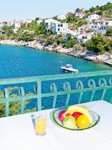 a plate of fruit on a table with a view of the water at Apartment Jelka in Ražanj