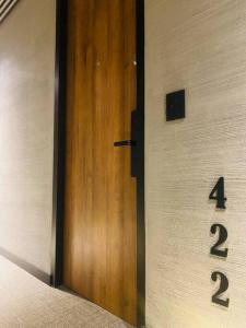 una puerta de madera con dos números en una pared en exclusivo apartaestudio usaquen, en Bogotá