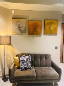 sala de estar con sofá y 3 pinturas en la pared en exclusivo apartaestudio usaquen, en Bogotá