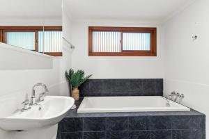 a bathroom with a white tub and a sink at Beach House in Lennox Head +12 photos