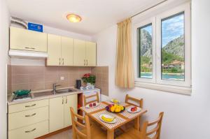 a kitchen and dining room with a table and a window at Apartments Mira in Omiš