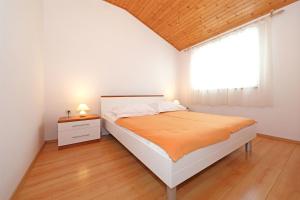 ein weißes Schlafzimmer mit einem Bett und einem Fenster in der Unterkunft Apartments Boris in Vodice