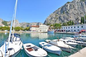 a group of boats docked in a harbor with a mountain at Apartments Mira in Omiš