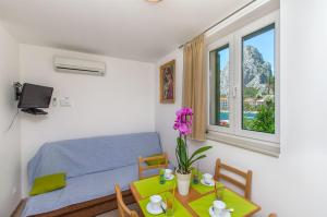 a small room with a bed and a table and a window at Apartments Mira in Omiš