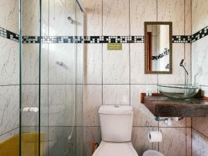 a bathroom with a toilet and a glass shower at Pousada Araucária Village in Campos do Jordão +181 photos