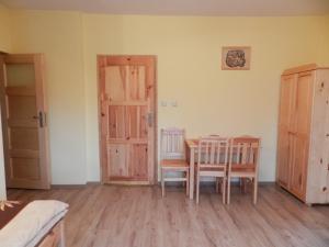 - une chambre avec une table, des chaises et une porte dans l'établissement Pokoje Gościnne Przystań KAJA w Sobieskach nad Wkrą, à Sobieski