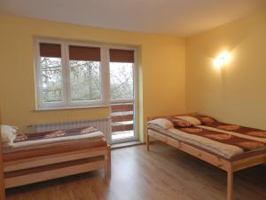 sypialnia z 2 łóżkami i oknem w obiekcie Pokoje Gościnne Przystań KAJA w Sobieskach nad Wkrą w mieście Sobieski