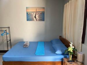 a bedroom with a blue bed in a room at Alona Bohol Backpackers Hostel in Panglao