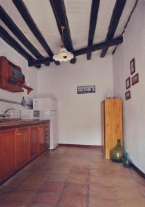 cocina con armarios de madera y nevera blanca en Casa Rural El Palmar en Vallehermoso