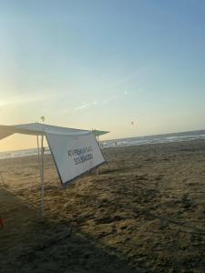 Un paraguas en la playa con un cartel. en Blue Diamond House, en Cartagena de Indias