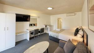 um quarto de hotel com uma cama e uma sala de estar em City Reach Motel em Wangaratta