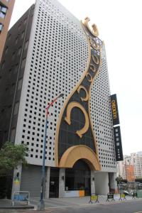 un edificio alto con una gran señal de oro. en CHECK inn Taichung Qinghai en Taichung