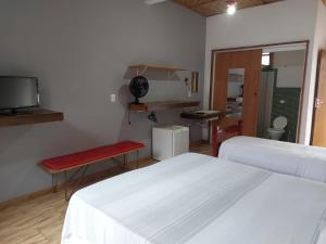 Zimmer mit 2 Betten, einem Tisch und einem TV in der Unterkunft Pousada Santa Maria in Tiradentes