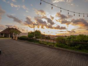 a sunset over a boardwalk with lights on it at Jambuluwuk Oceano Seminyak Hotel in Seminyak