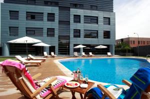 une piscine avec des chaises longues et un hôtel dans l'établissement Hotel Nuevo Boston, à Madrid