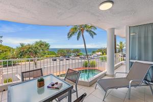 balcón con mesa, sillas y vistas al océano en La Mer Sunshine Beachfront, en Sunshine Beach