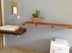 a bathroom with a sink and a shelf on the wall at Pousada Santa Maria in Tiradentes