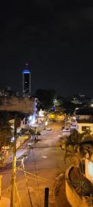 an empty city street at night with a building at Piazza Granada in Cali