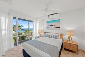 a bedroom with a bed and a large window at La Mer Sunshine Beachfront in Sunshine Beach