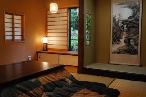 a living room with a bed and a window at EK House Hakone Shushinso 箱根修身荘 in Onsensō