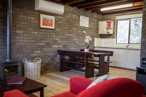 cocina y sala de estar con mesa y chimenea en Caves Road Chalets, en Margaret River Town