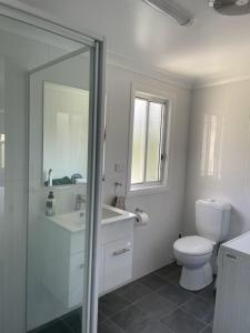 ein weißes Bad mit einem WC und einem Waschbecken in der Unterkunft Units on Robertson in Mudgee