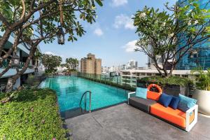 曼谷MUU Bangkok, Small Luxury Hotels of the World的大楼内一个带沙发的游泳池