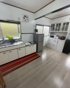 a kitchen with white cabinets and a stainless steel refrigerator at FRIENDS in Futae